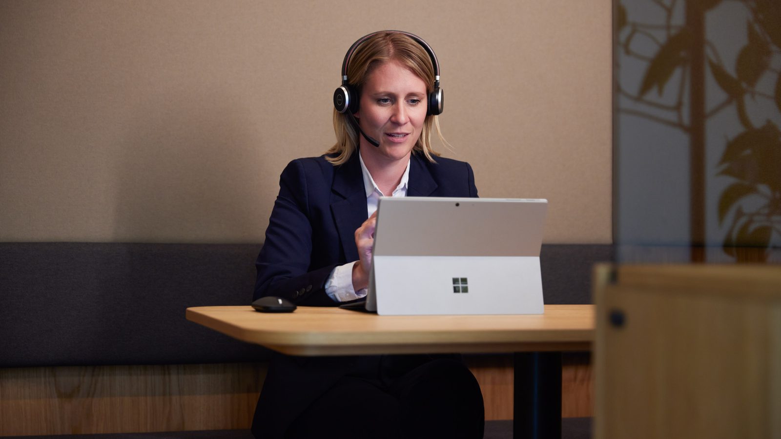 A ReqPOOL consultant wearing a headset works attentively on a laptop.