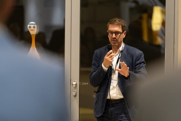 Speaker gesturing while talking into a microphone in a glass door