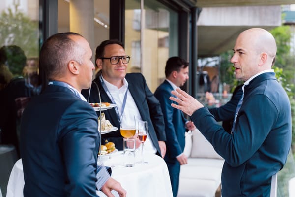 Guests talking at a table with finger food and drinks