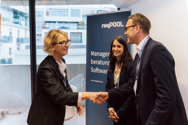 Greeting with a handshake in front of a ReqPOOL banner