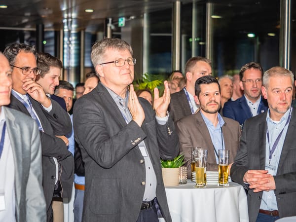 Publikum applaudiert, im Vordergrund ein Gast mit Brille