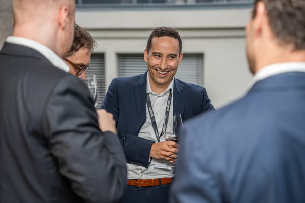 Laughing guest with a drink talking to other guests
