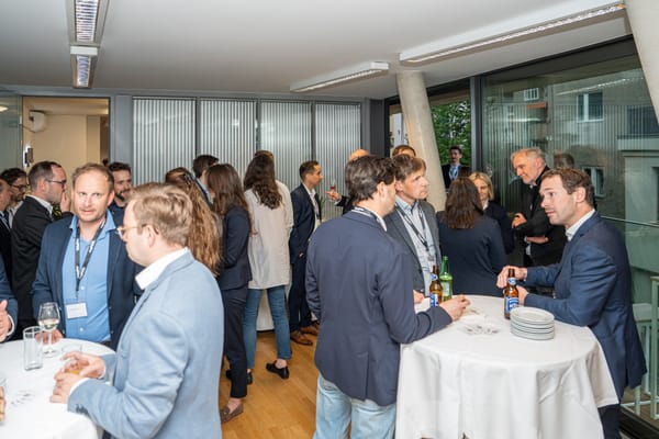 Guests at standing tables with drinks in the event room