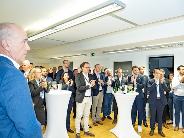 Guests applauding at standing tables, a ReqPOOL banner in the background
