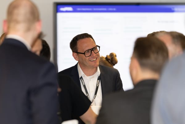 Lächelnder Gast vor einem Bildschirm mit der ReqPOOL-Plattform