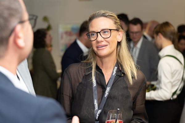 Frau mit Brille und Cocktailglas im angeregten Gespräch