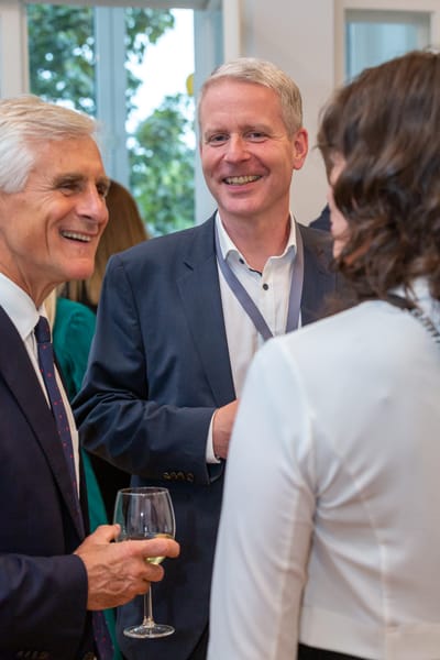 Guests with a wine glass in conversation, portrait format